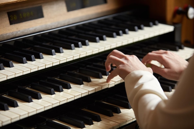 Weibliche Hände auf der Tastatur der Orgelnahaufnahme