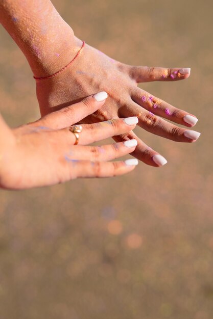 Weibliche Hände bedeckt mit Holi-Farbpulver