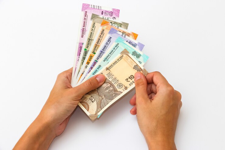 Foto weibliche hände, die brandneue 10, 50, 100, 200, 500 und 2000 indische rupien-banknoten halten.