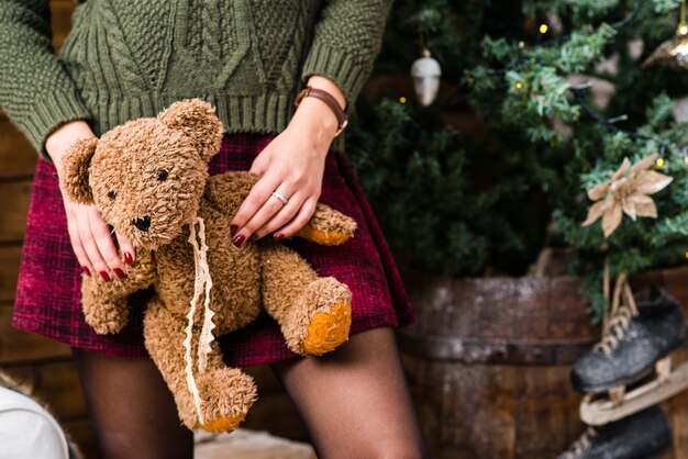 Weibliche Hände, die einen netten Teddybären halten. Weihnachtsgeschenk.