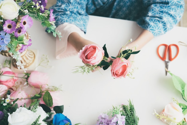 Weibliche Hände, die schöne Blumenzusammensetzung im Blumenshop machen