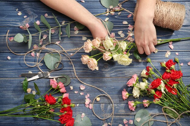 Foto weibliche hände, die schöne draufsicht des blumenstraußes machen