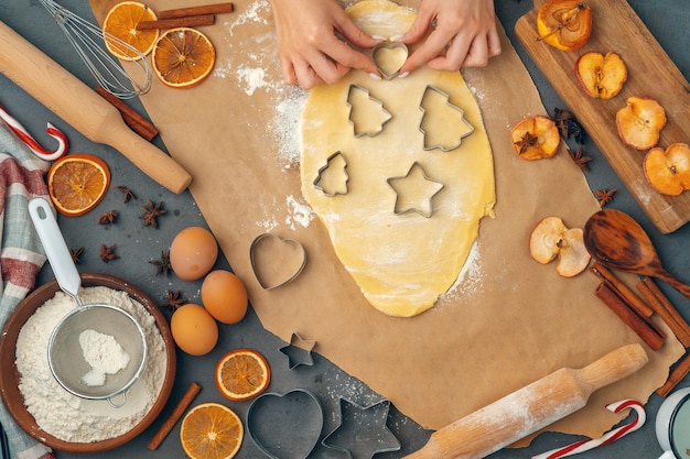 weibliche Hände, die zu Hause Plätzchen vom frischen Teig machen