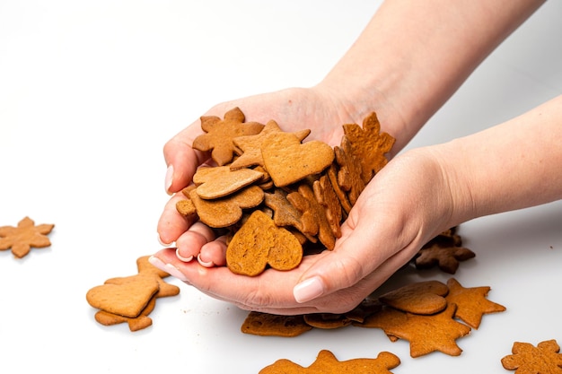 Weibliche Hände geben Lebkuchen, der auf weißer Kopienraumnahaufnahme lokalisiert wird