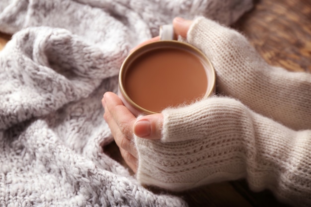 Weibliche Hände in Handschuhen mit einer Tasse Kaffee, Nahaufnahme coffee