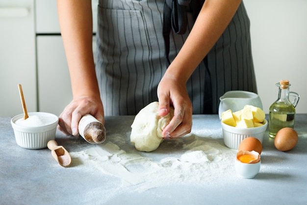 Foto weibliche hände kneten den teig und backen hintergrund. zutaten kochen