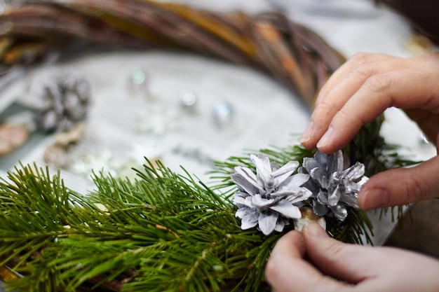 weibliche Hände machen Blumenkranz