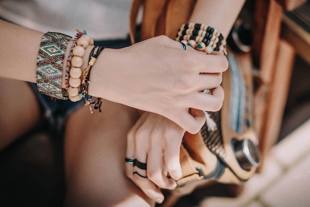 Weibliche Hände mit Boho-Zubehör, Armbänder aus farbigen Perlen