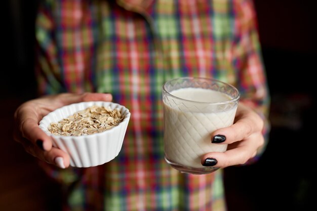 Weibliche Hände mit Glas veganer Hafermilch Alternative Arten von Pflanzenmilch aus verschiedenen Getreidesorten Sauberes Essen Gesunde ErnährungxA