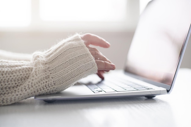 Weibliche Hände mit Laptop-Tastatur-Nahaufnahme Home-Office-Konzept