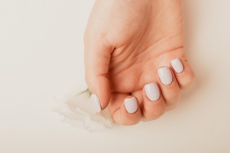 Weibliche Hände mit rosa Maniküre Klassisches Brautnägeldesign Nagelhygiene- und Pflegekonzept