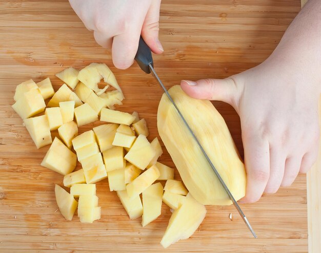 Foto weibliche hände schneiden kartoffeln