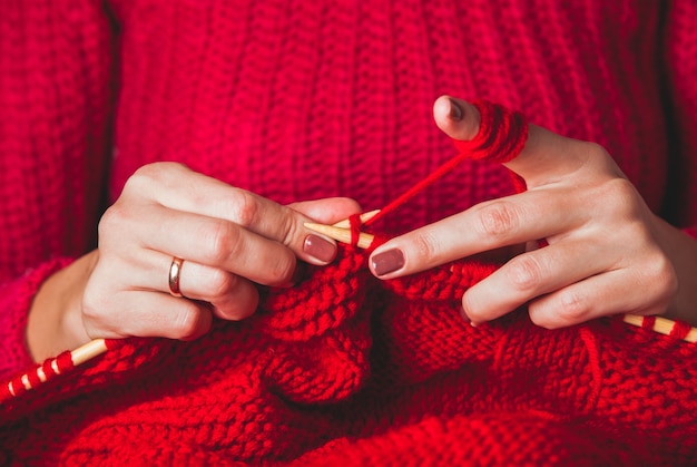 Weibliche Hände stricken Pullover