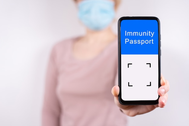 Weibliche Hand, die ein Handy mit digitalem Immunitätspass hält