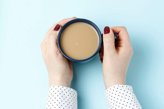 Weibliche Hand, die einen Tasse Kaffee hält