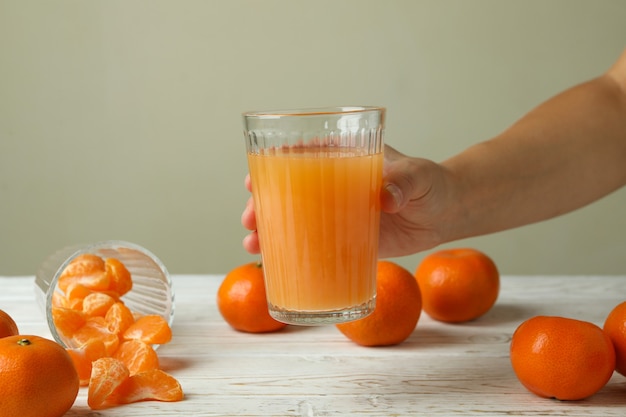 Weibliche Hand hält Glas mit Mandarinensaft, Nahaufnahme