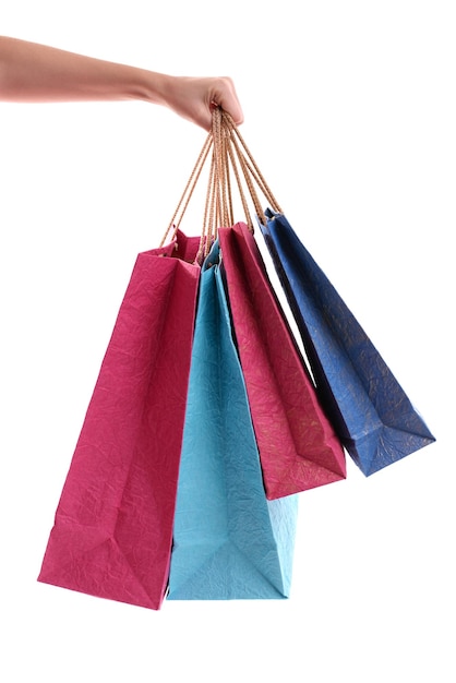 Weibliche Hand hält Papiertüten, die auf Weiß isoliert sind