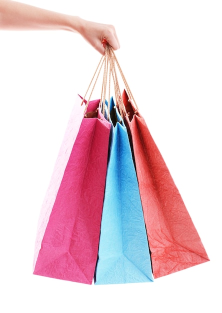Weibliche Hand hält Papiertüten, die auf Weiß isoliert sind