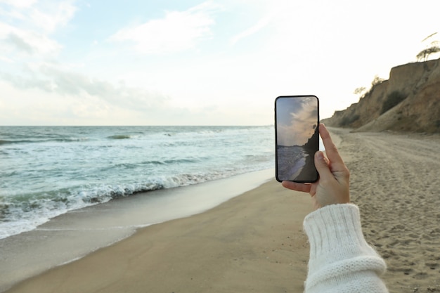 Weibliche Hand halten Telefon mit Selfie auf See