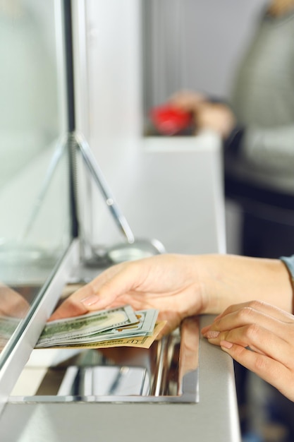 Foto weibliche hand mit geld im kassenfenster geldwechselkonzept