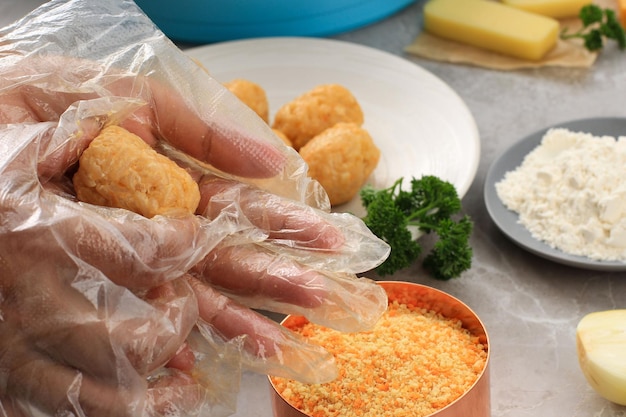 Weibliche Hand mit Plastikhandschuhen Arancini runden Reis Arancini Kochen Schritt für Schritt in der Küche