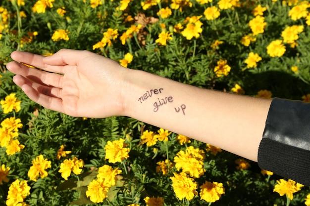 Weibliche Hand mit Tätowierung in gelben Blumen