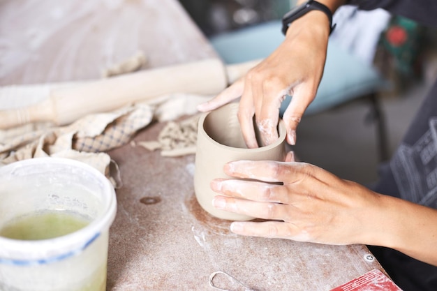 Weibliche Keramikerin, die im Töpferstudio arbeitet Hände des Keramikers Dirty Of Clay Prozess der Herstellung von Töpferwaren Meisterkeramikerin arbeitet in ihrem Studio