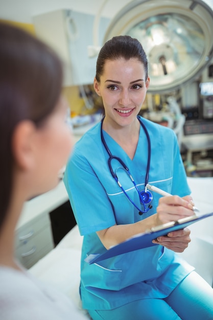 Foto weibliche krankenschwester, die auf zwischenablage schreibt