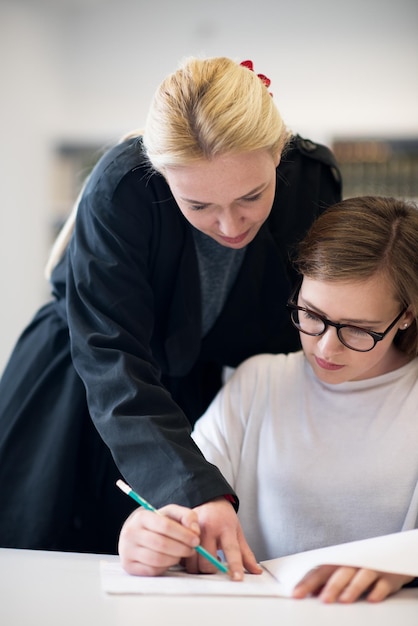 Foto weibliche lehrerin, die den schülern im unterricht bei unterricht hilft und unterstützung bietet