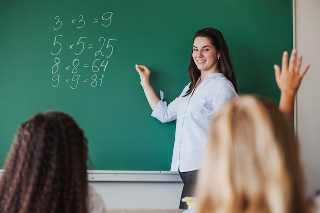 Foto weibliche lehrerin steht vor tafel