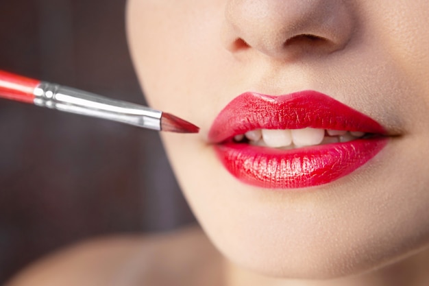 Weibliche Lippen mit roter Lippenstiftnahaufnahme