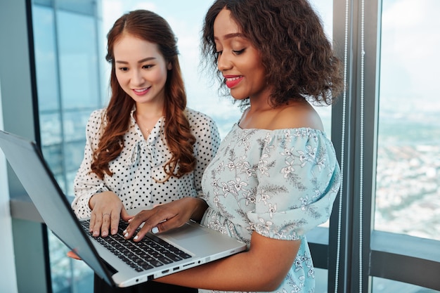 Weibliche Manager diskutieren Artikel auf Laptop