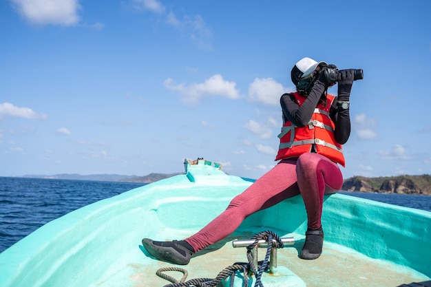 Weibliche Meeresbiologin, die Fotos macht, während sie an einem Boot arbeitet