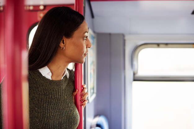 Weibliche Passagiere, die an den Türen im Zug stehen und aus dem Fenster schauen