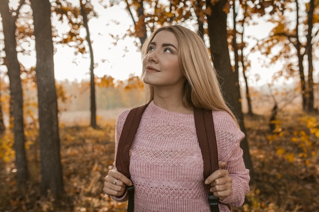 Weibliche Reisende bewundert Schönheit des Herbstwaldes