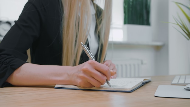 Weibliche Schrift mit Stift im Notizblock.