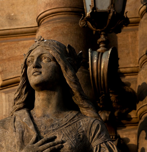 weibliche Skulptur in zeitgemäßer Kleidung, die den Sonnenuntergang betrachtet