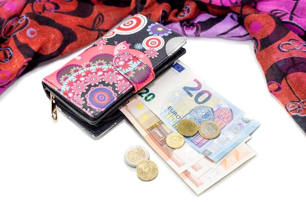 Weibliche stilvolle neue mehrfarbige Brieftasche und Euro auf dem Tisch in der Nähe