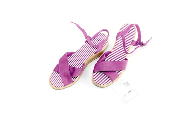 Weibliche violette Sandalen aus Stoff auf einer Fersennahaufnahme auf weißem Hintergrund