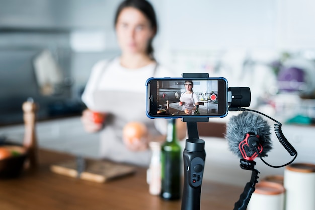 Weibliche Vlogger-Aufnahme, die zu Hause in Verbindung stehende Sendung kocht