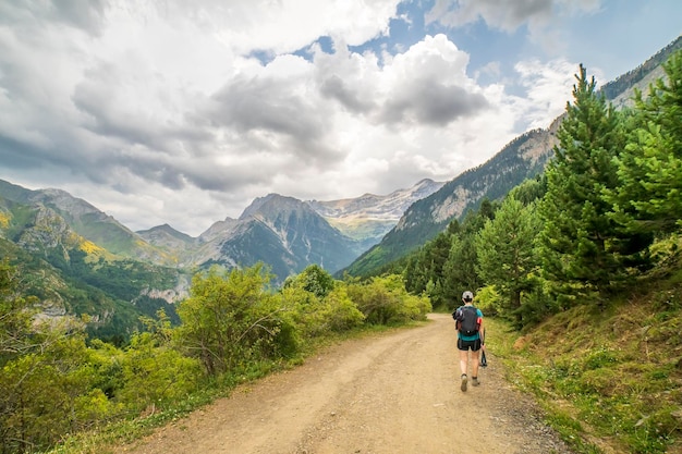 Weibliche Wanderer, die an einem Tag mit grauen Wolken in das Bujaruelo-Tal hinuntergehen Nationalpark Ordesa y Monte Perdido