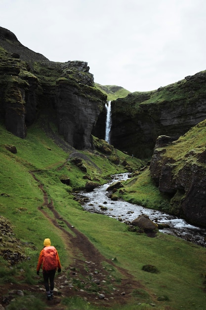 Weibliche Wanderer mit Blick auf den Wasserfall Kvernufoss in Südisland