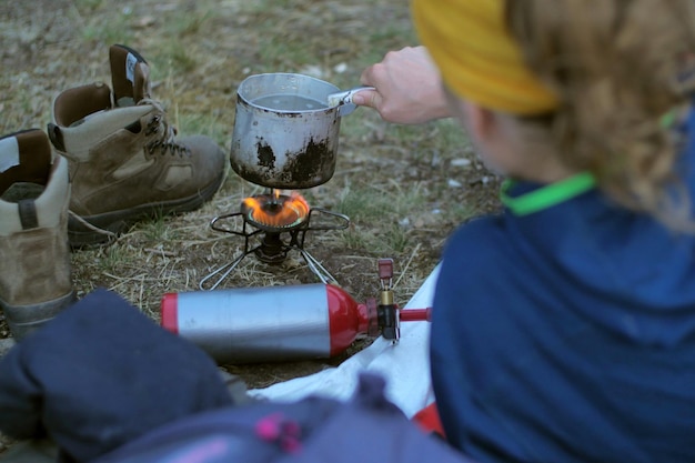 Foto weibliche wandererin trinkt, während sie sich während des campings auf dem bett lehnt