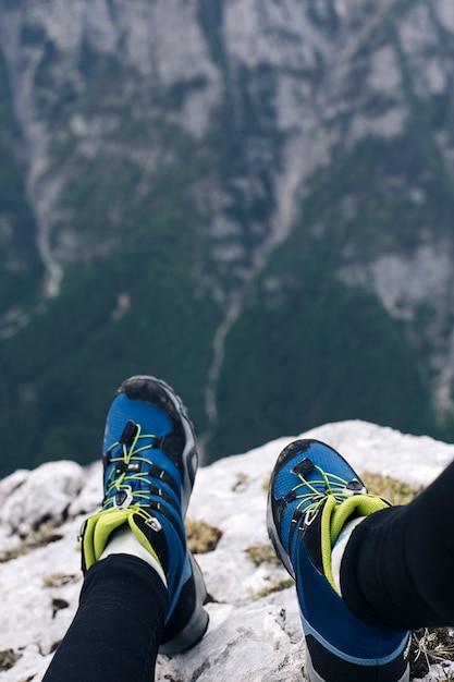 Weibliche Wandererschuhe am Rand einer Klippe