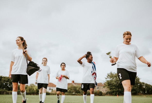 Weibliche weibliche Fußballspieler, die auf ein Feld gehen