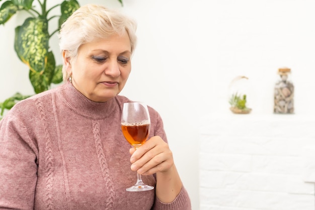 Weiblicher älterer trinkender Rotwein - getrennt auf weißem Hintergrund.
