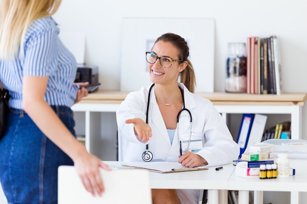 Weiblicher Arzt empfängt ihre Patientin im Büro.