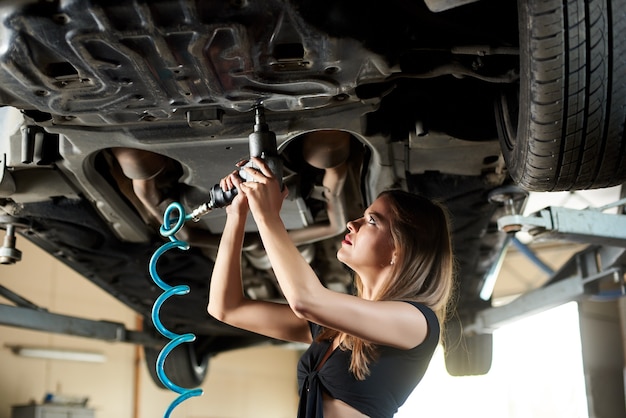 Weiblicher Automechaniker repariert Auto in der Garage