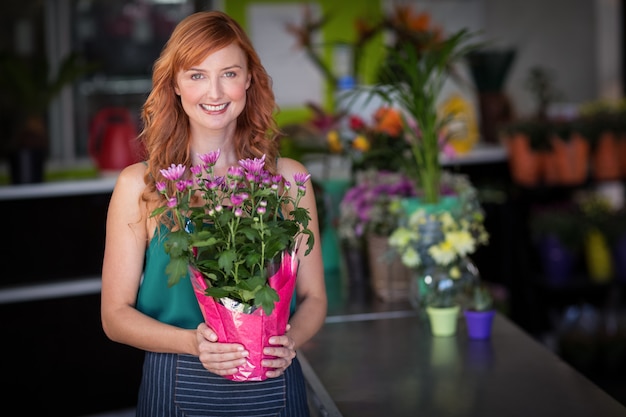 Weiblicher Florist, der Blumenstrauß im Blumenladen hält