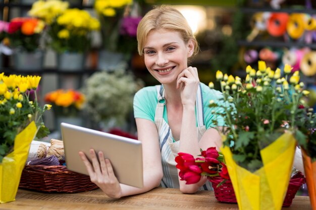 Weiblicher Florist, der digitales Tablett hält